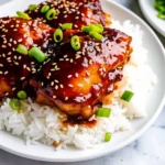 Slow cooker honey garlic chicken with sticky sauce served over rice.